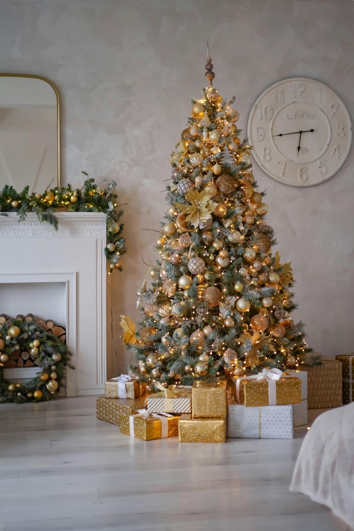 A decorated tall Christmas tree with gifts and ornaments