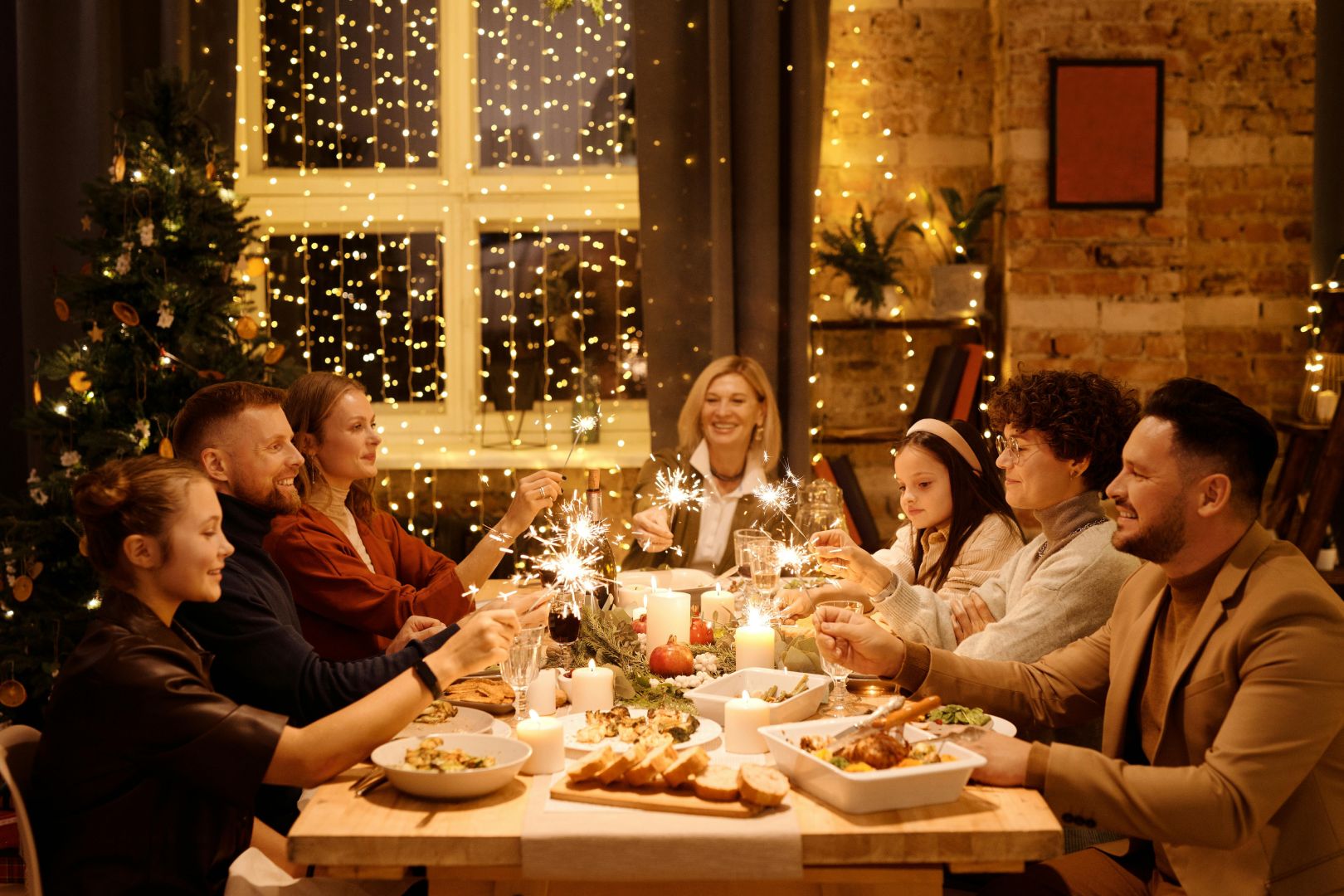 A family celebrating Christmas together with sparkles in hand before eating dinner